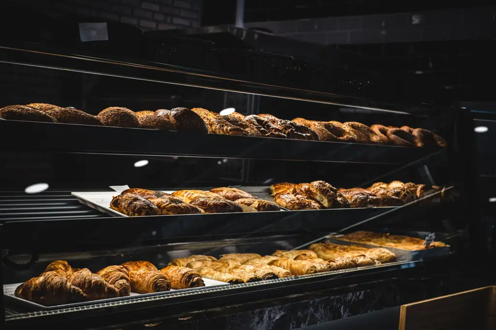 Glass display case lined with croissants and glazed pastries