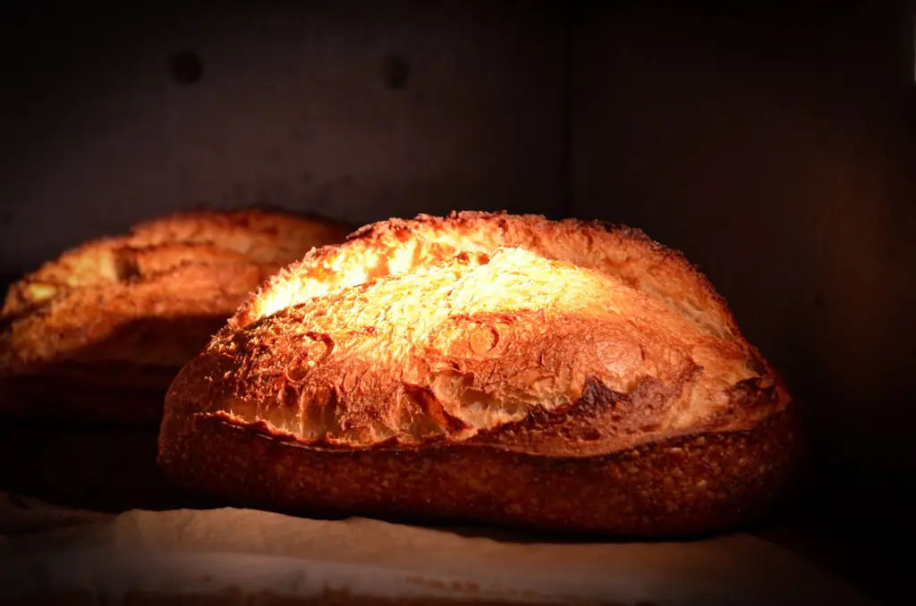 A golden sourdough loaf glowing inside a hot oven